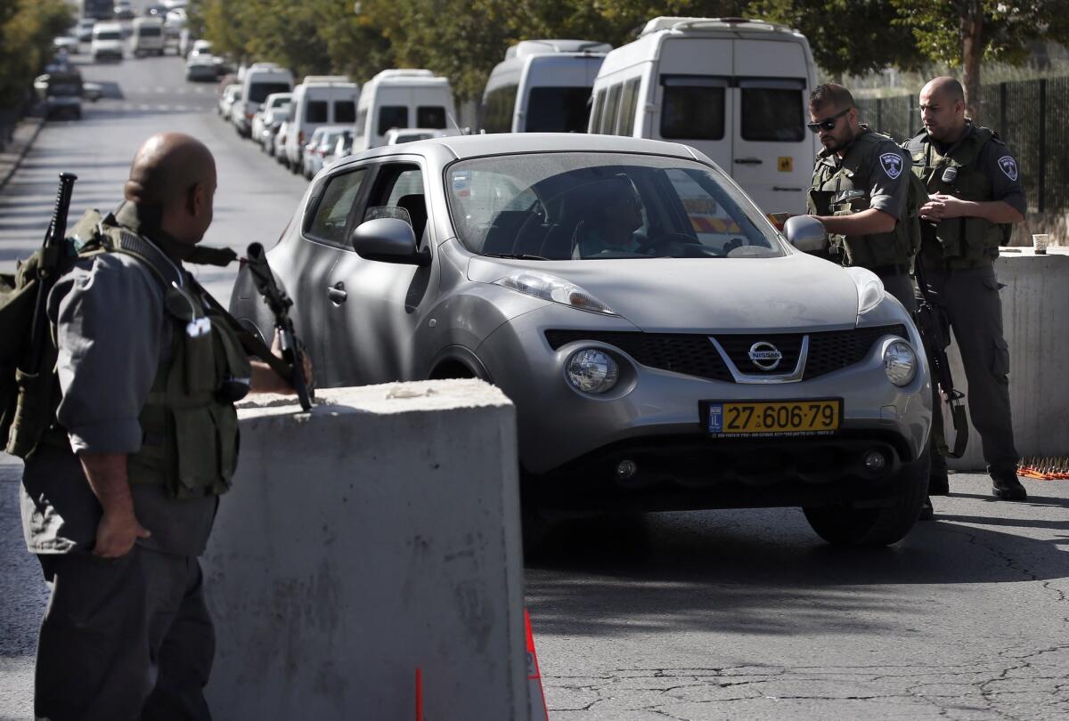 Israeli security personnel check a Palestinian vehicle at a newly installed road block Thursday in east Jerusalem.