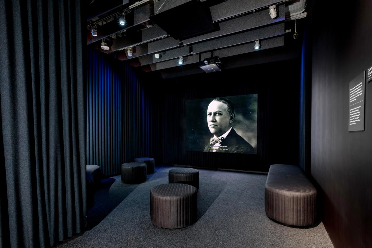 A photo of a sitting area with a large screen to display a documentary at the Academy Museum.