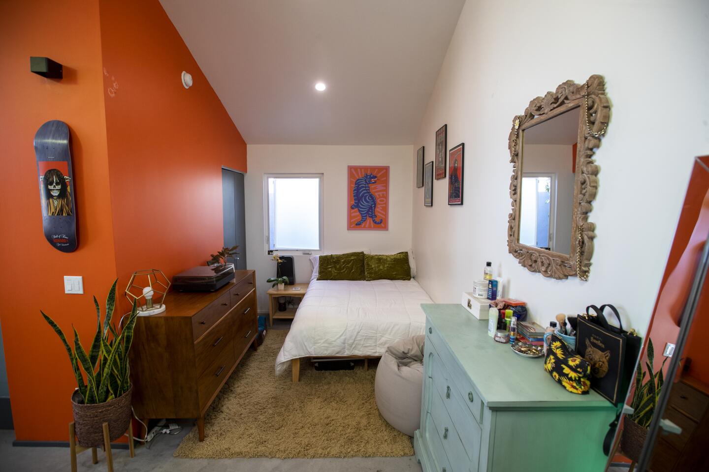 The narrow bedroom with two dressers.