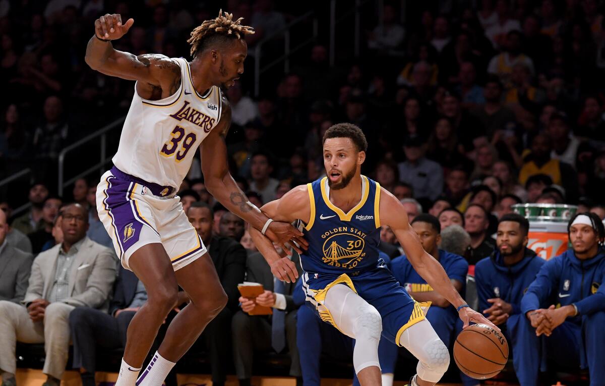 Golden State Warriors point guard Stephen Curry tries to drive around Lakers center Dwight Howard.