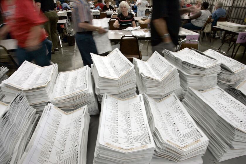 Workers at the registrar of voters office in Santa Ana open stacks of absentee ballots the morning after the midterm election in November 2006.