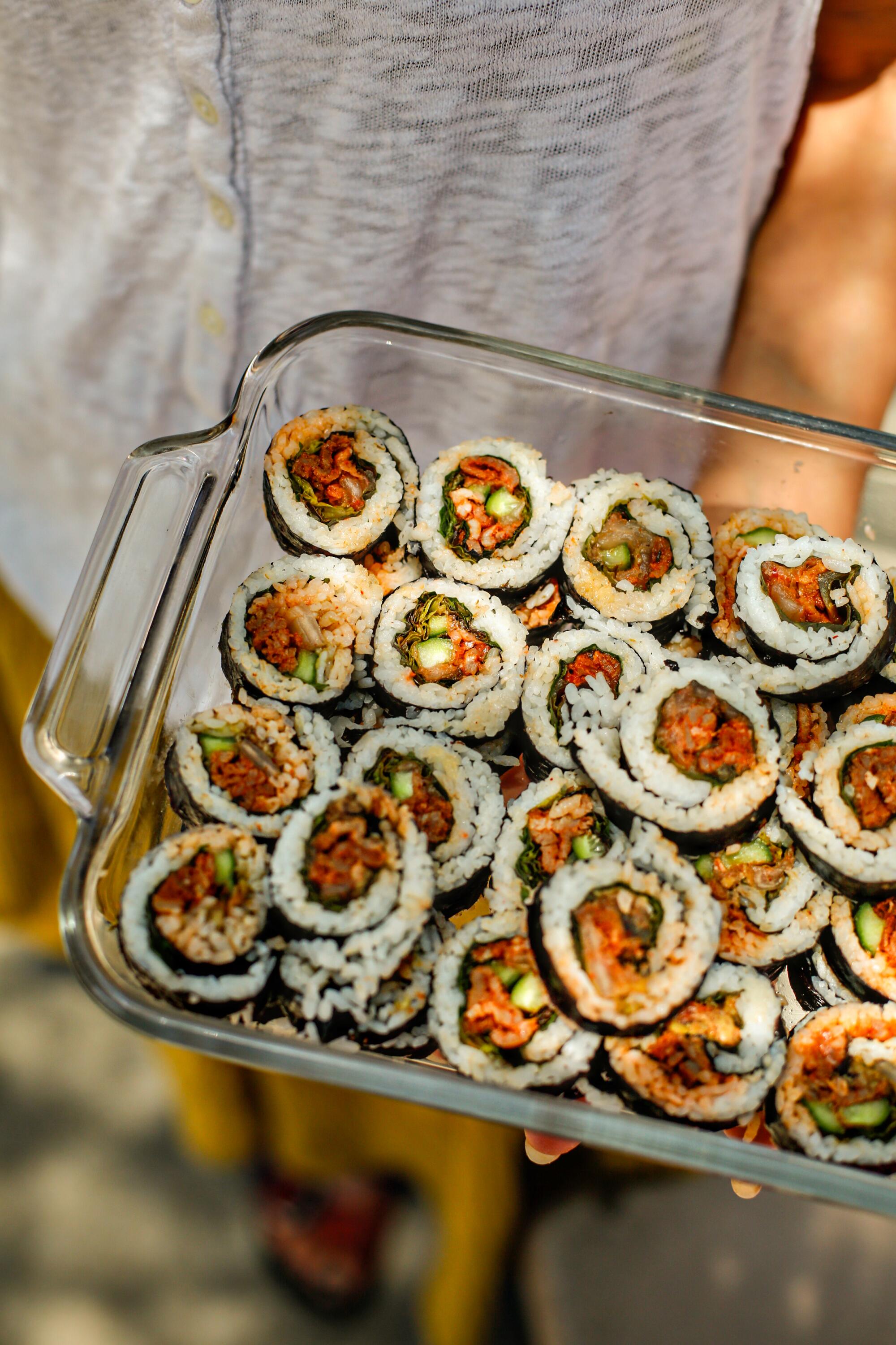 Serena Jackson holds kimbap in a glass container.