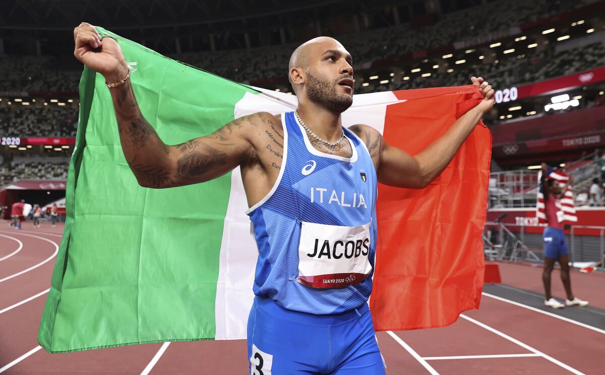 Lamont Marcell Jacobs of Italy celebrates after winning the final of the men's 100-meters at the 2020 Summer Olympics, Sunday, Aug. 1, 2021, in Tokyo, Japan. (Cameron Spencer/Pool Photo via AP)