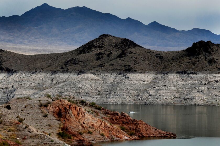 LAKE MEAD, NEV. - MAY 16, 2022. Boaters navigate Lake Mead, the largest reservoir in the United States, created by the construction of the Hoover Dam in the channel of the Colorado River. The white surfaces on the lake's rocky banks show how low water levels have dropped after more than a decade of persistent and worsening drought conditions in the Southwestern U.S. This year, the lake's water level hads dropped to the lowest in history. It is lower than it has been since the reservoir was filled some 90 years ago. (Luis Sinco / Los Angeles Times)