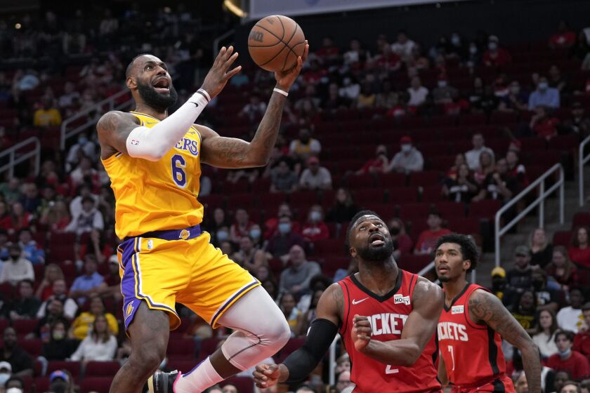 Los Angeles Lakers forward LeBron James (6) shoots as Houston Rockets forward David Nwaba, middle, defends during the first half of an NBA basketball game Tuesday, Dec. 28, 2021, in Houston. (AP Photo/Eric Christian Smith)