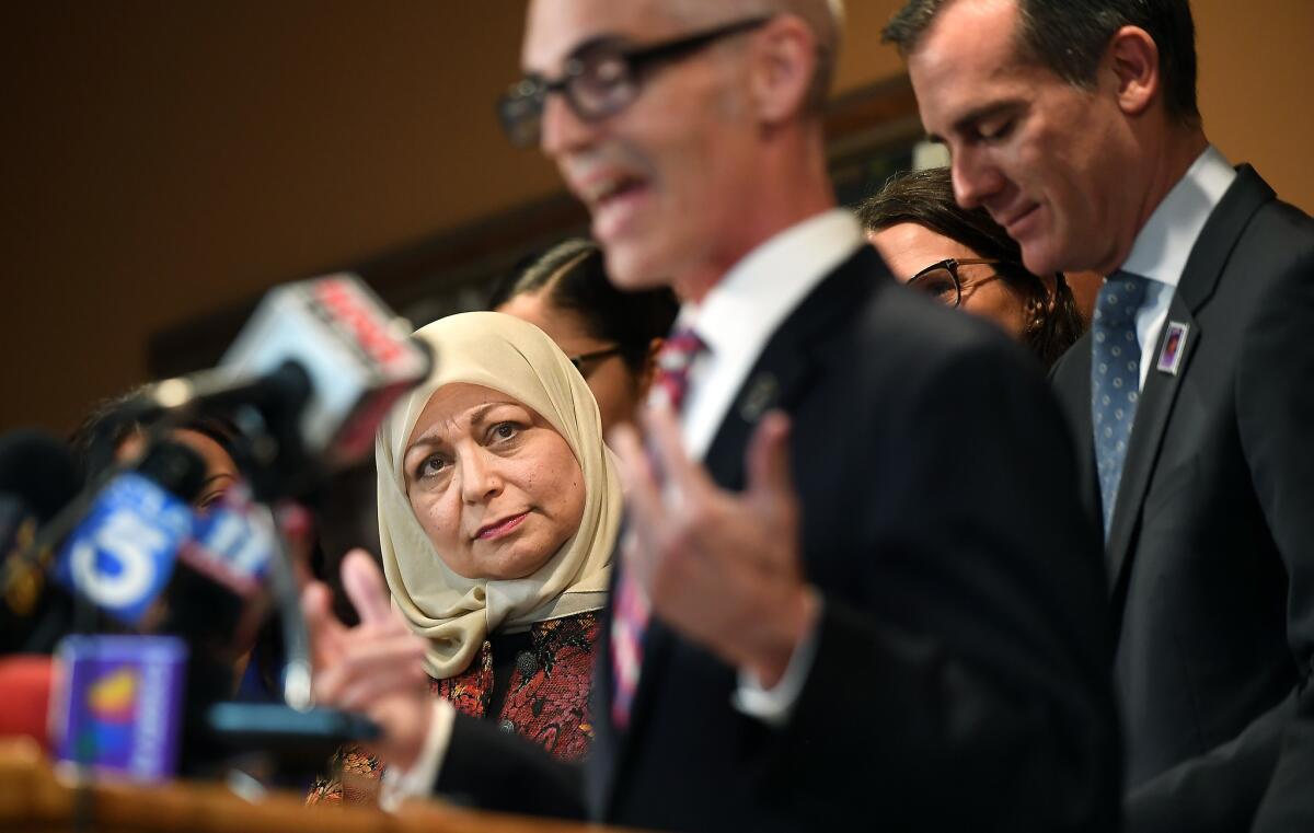 Hedab Tarifi, chairwoman of the Islamic Center of Southern California, listens as Los Angeles City Councilman Mitch O'Farrell speaks at a news conference at the center. L.A. Mayor Eric Garcetti, right, also spoke.