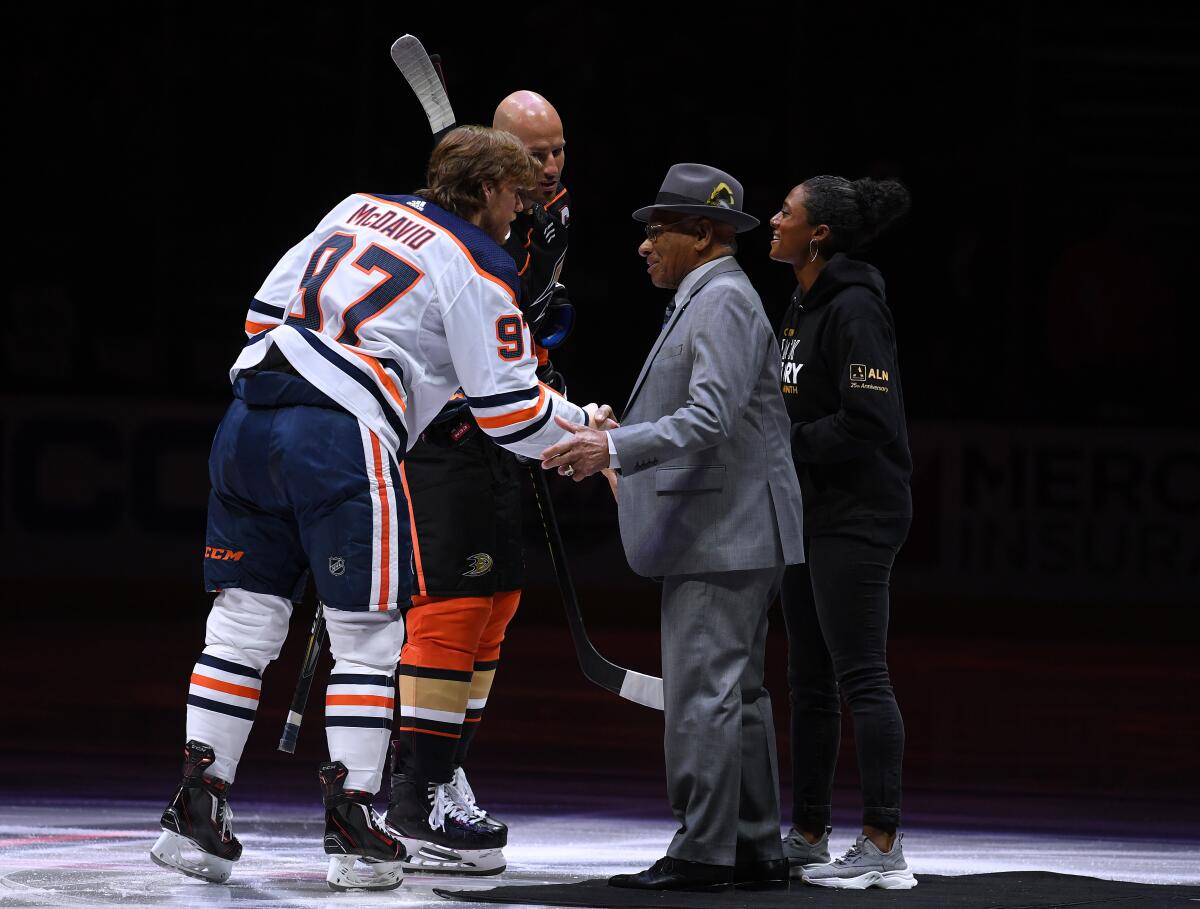 Connor McDavid of the Edmonton Oilers shakes hands with Willie O'Ree along with Blake Bolden and Ryan Getzlaf of the Ducks before the game in celebration of Black History Month at Honda Center on Wednesday.