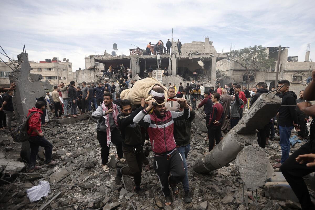 Palestinians evacuate wounded people after Israeli airstrikes in the Khan Younis refugee camp 