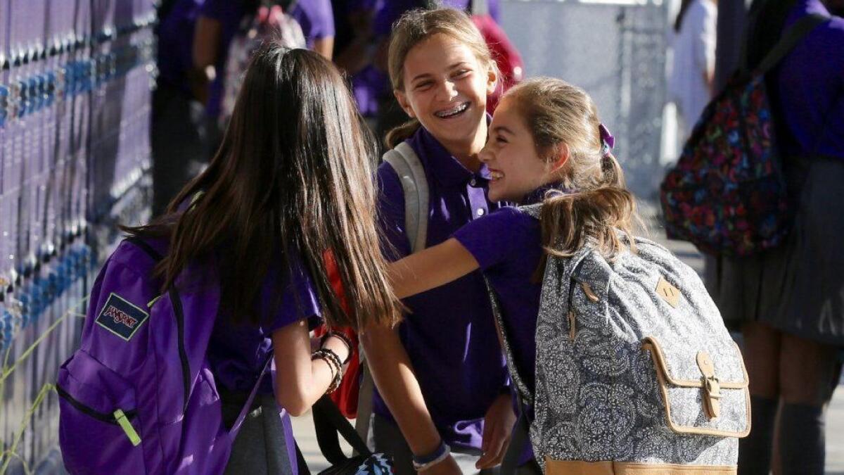 Leila Shiva, right, greets her friends Delia Mizrahi, center, and Alexis Escuadro on first day of classes at the Girls Academic Leadership Academy in Los Angeles in 2016. Now the school is being renamed after retiring Supt. Michelle King.