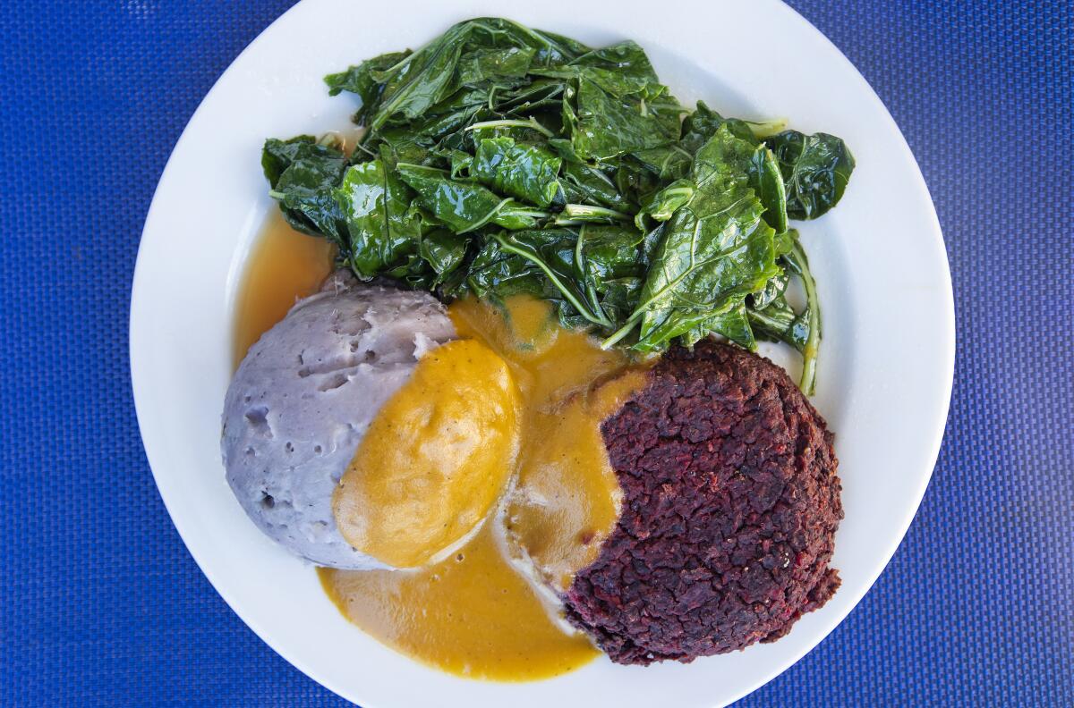 The BountiBurger mix plate comes with smashed sweet potatoes, seasoned wilted greens and mushroom gravy at Sweet Potato Kitchen in Hawi, Hawaii.