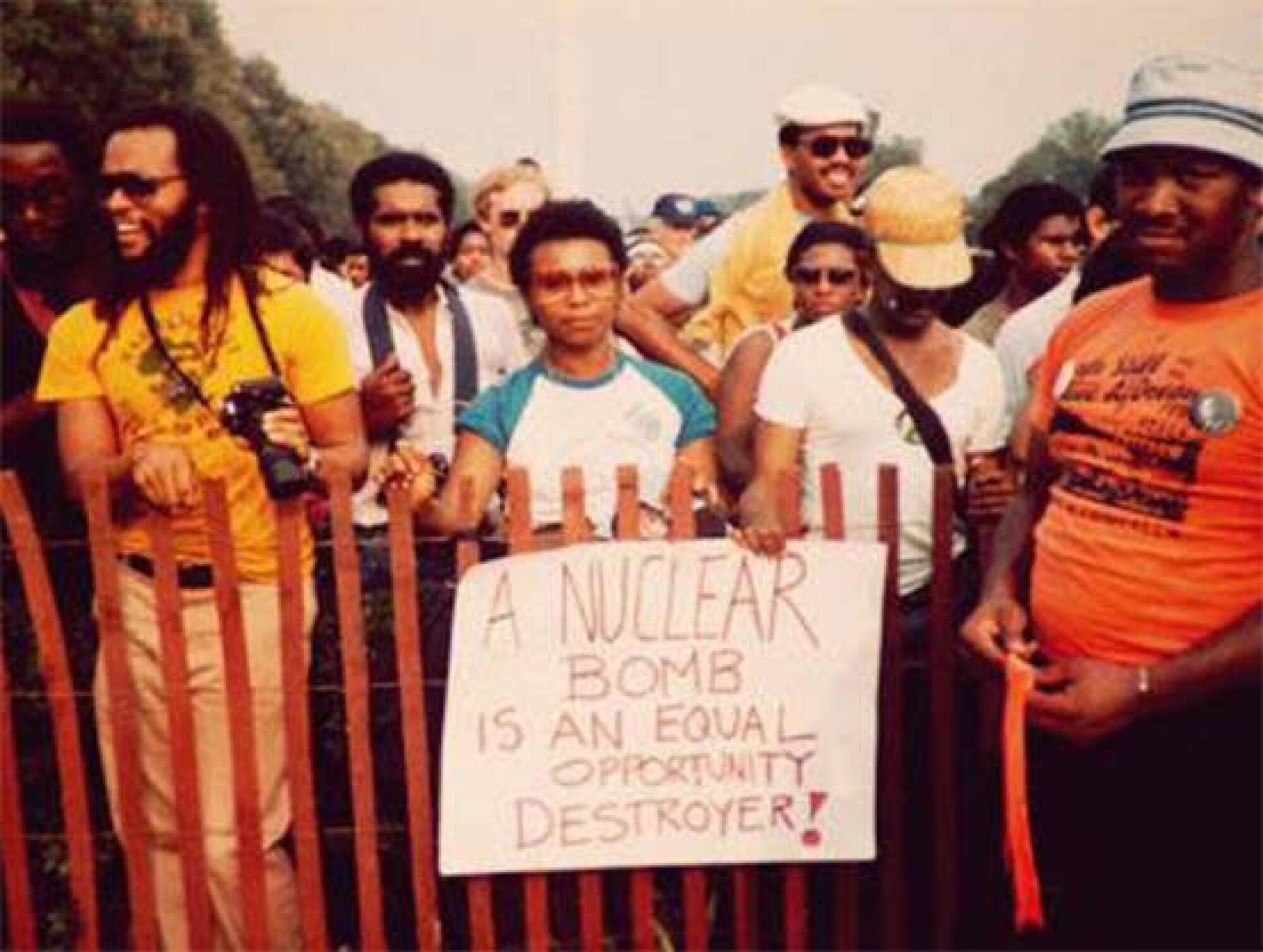 Barbara Lee surrounded by other people behind a fence in 1978