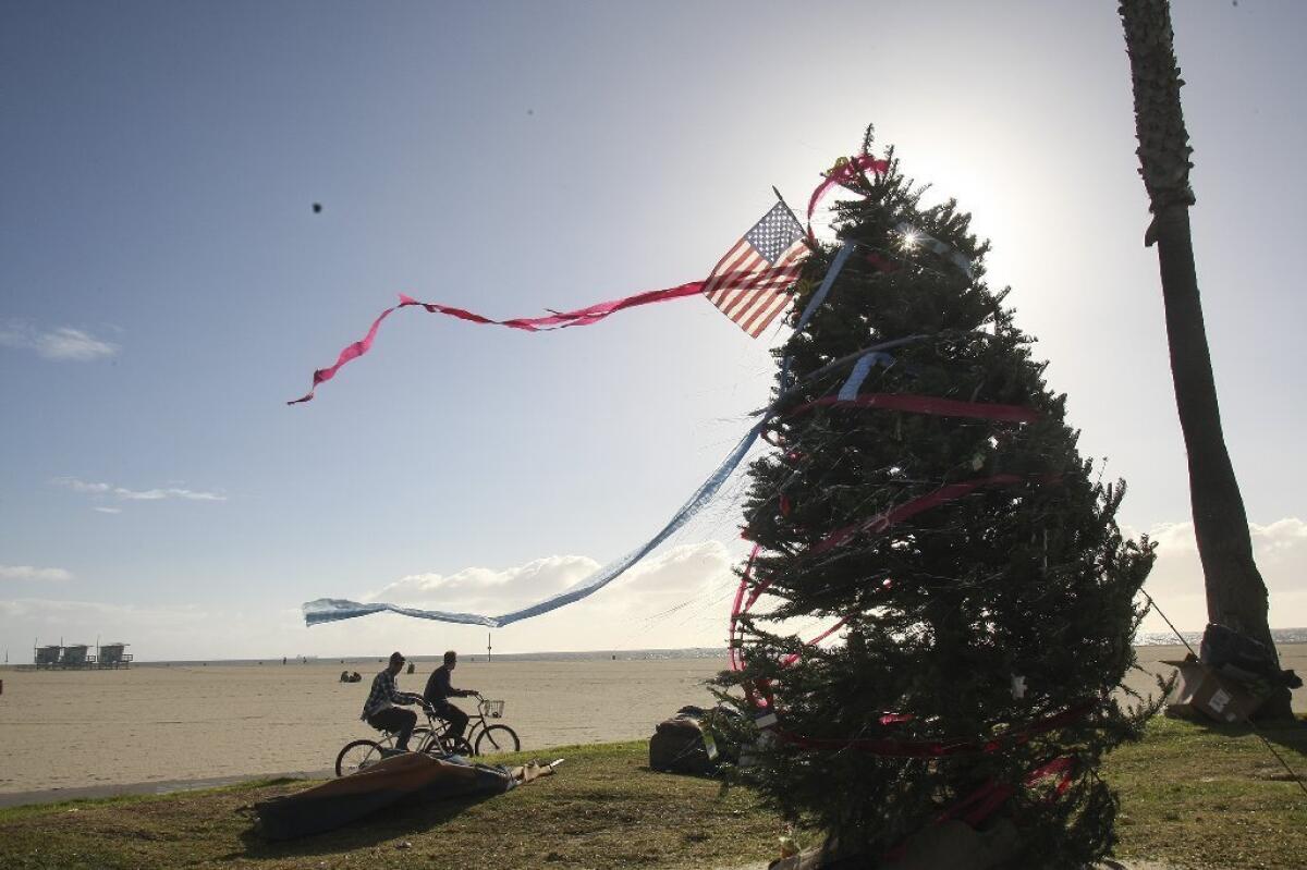 Bikers pass by a Christmas tree at Venice Beach on Dec. 19.