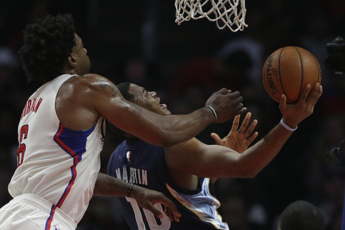 Clippers center DeAndre Jordan tries to block the shot of Grizzlies forward Jarell Martin during first half of a game on April 12 at Staples Center.