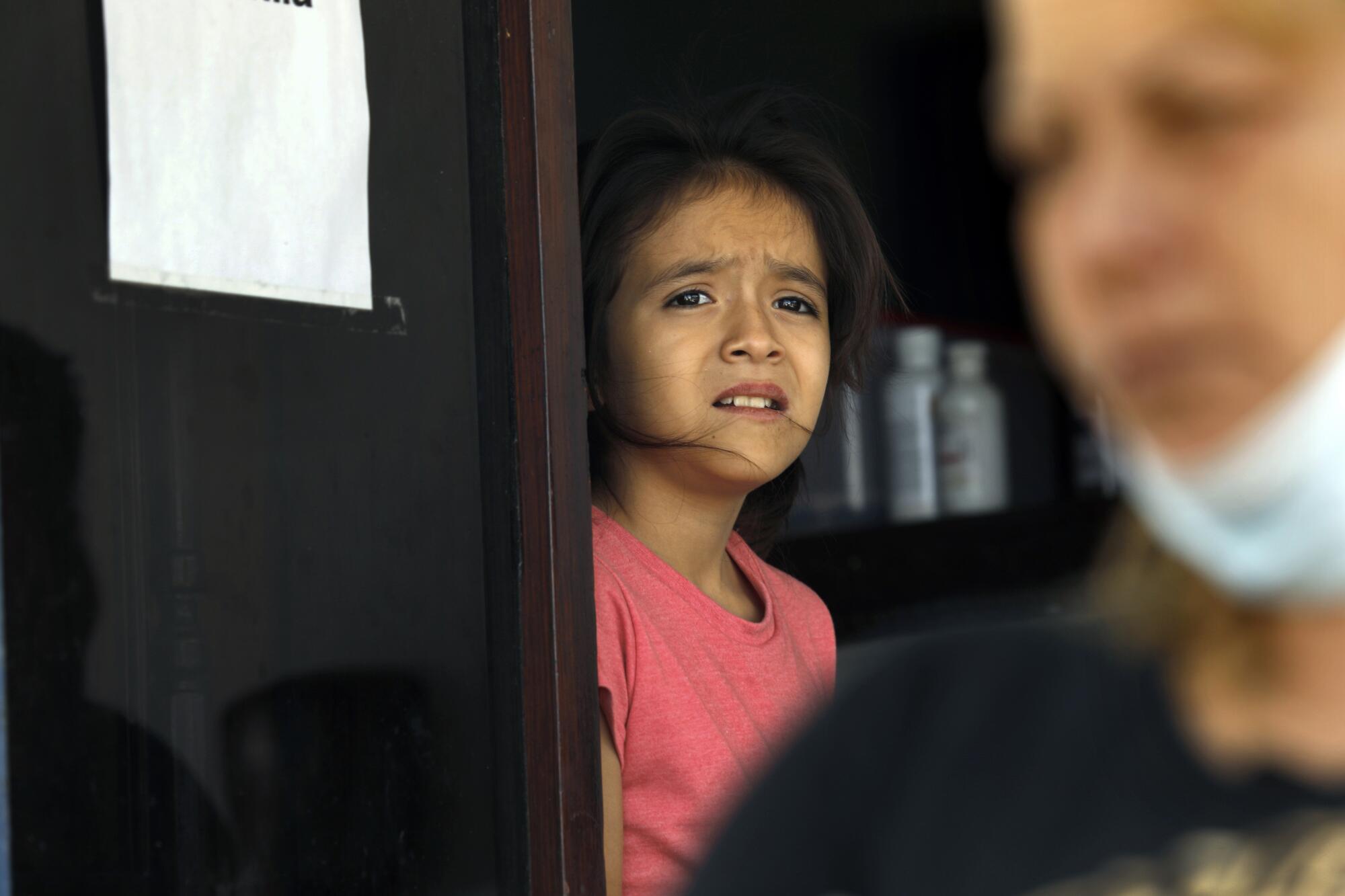 A girl stands in a doorway. 