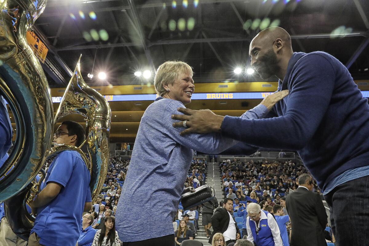 Anne Meyers Drysdale greets Kobe Bryant before a women's basketball game between UCLA and UConn.