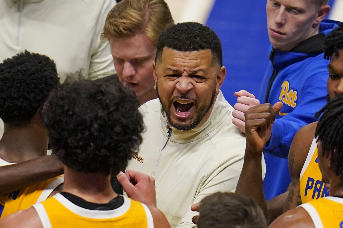Pittsburgh coach Jeff Capel, center, gives instruction during a timeout during the first half of the team's NCAA college basketball game against Colgate in Pittsburgh, Thursday, Dec. 9, 2021. (AP Photo/Gene J. Puskar)