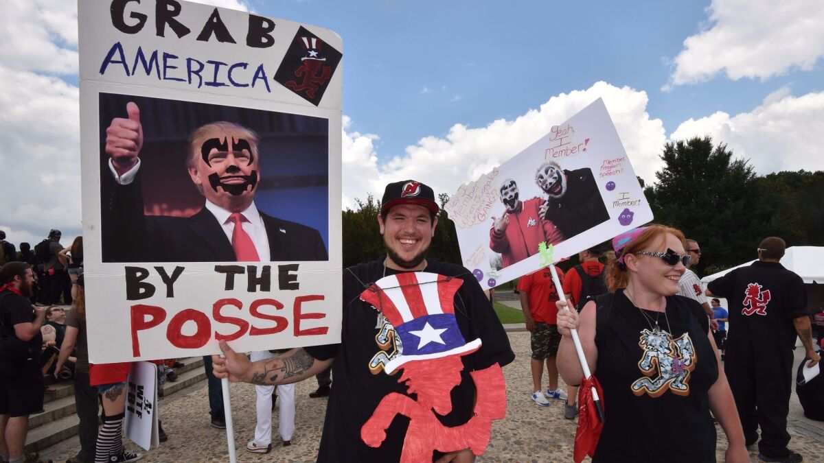 Fans of the group Insane Clown Posse, known as Juggalos, hold placards mocking President Trump during a Sept. 16 protest in Washington.