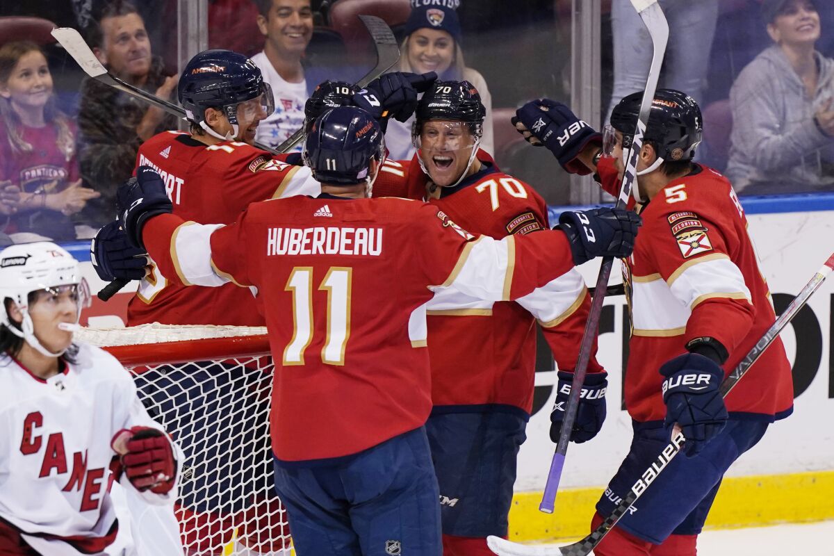 Florida Panthers teammates congratulate right wing Patric Hornqvist (70) after he scored a goal during the first period at an NHL hockey game against the Carolina Hurricanes, Saturday, Nov. 6, 2021, in Sunrise, Fla. (AP Photo/Marta Lavandier)