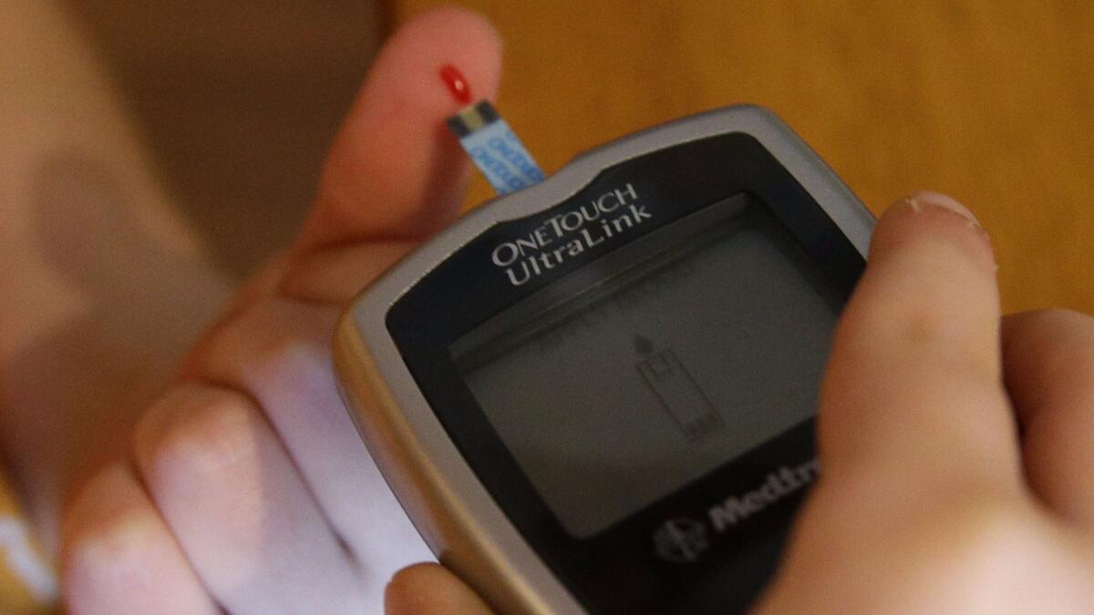 A child pricks his finger to test his blood sugar. (Nam Y. Huh / Associated Press)