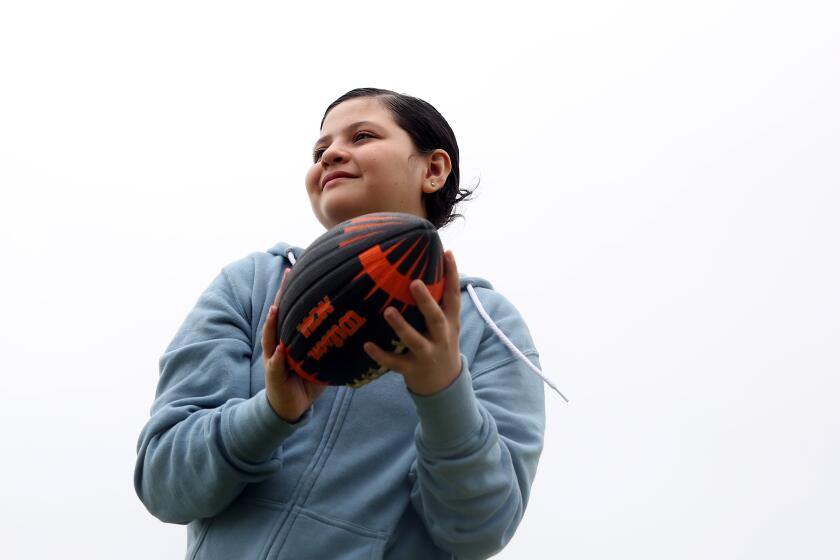 LOS ANGELES, CA - JUNE 23: Kayla Diaz, 12, tosses the football with her mom at Point Fermin Park in San Pedro on Tuesday, June 23, 2020 in Los Angeles, CA. After spending the majority of the last several months in doors to protect their compromised immune systems, they have found solace in coming to the park for fresh air occasionally. Before the coronavirus pandemic broke out, Kayla wished to go to Hawaii to go swimming after completing chemotherapy last year through Make-A-Wish. Due to a chemo port in her chest, she wasn't able to swim for the longest time, which is one of her favorite hobbies. Her wish was going to be in April but is now postponed. Marlene, is a hair dresser and is now out of work due to the coronavirus outbreak. She had a baby in January and was just getting back to work when everything hit. (Dania Maxwell / Los Angeles Times)