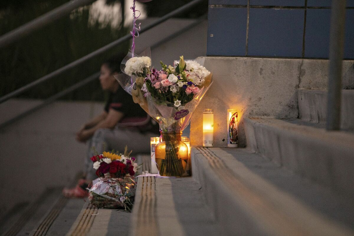 Students and community members place flowers and candles at Helen Bernstein High School where a teenage girl died of an overdose on Thursday, Sept. 15, 2022, in Los Angeles. Authorities said multiple Los Angeles teenagers have overdosed on pills likely laced with fentanyl over the past month, including the 15-year-old girl who died on the high school campus. (Jason Armond/Los Angeles Times via AP)