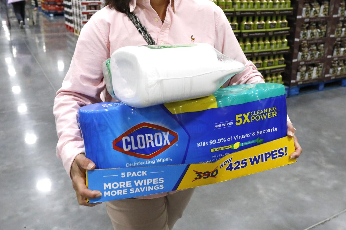 A female customer carries cleaning supplies at Costco