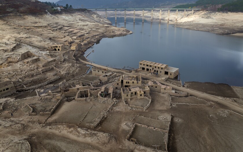 Parts of the old village of Aceredo, submerged three decades ago when a hydropower dam flooded the valley, are photographed emerged due to drought at the Lindoso reservoir, in northwestern Spain, Saturday, Feb. 12, 2022. Large sections of Spain are experiencing extreme or prolonged drought, with rainfall this winter at only one-third of the average in recent years. The situation is similar in neighboring Portugal, where 45% of the country is now enduring “severe” or “extreme” drought. (AP Photo/Emilio Morenatti)