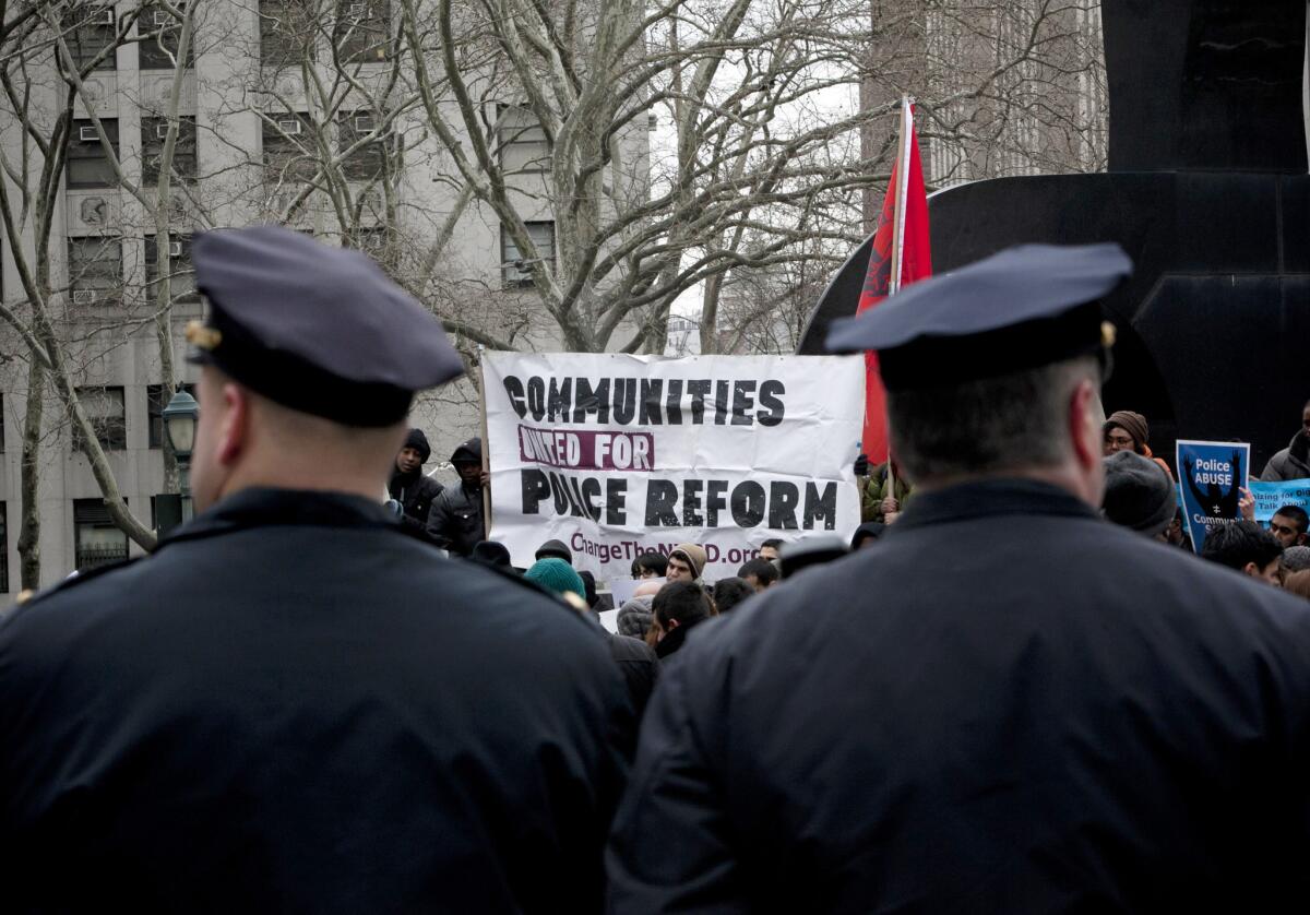 New York City police officers watch over a demonstration against the city's "stop and frisk" searches in lower Manhattan near Federal Court March 18, 2013.