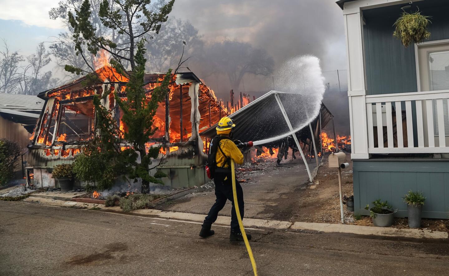 Firefighters battle flames at the Alpine Oaks Estates mobile home park on Friday during a fire in Alpine, California.