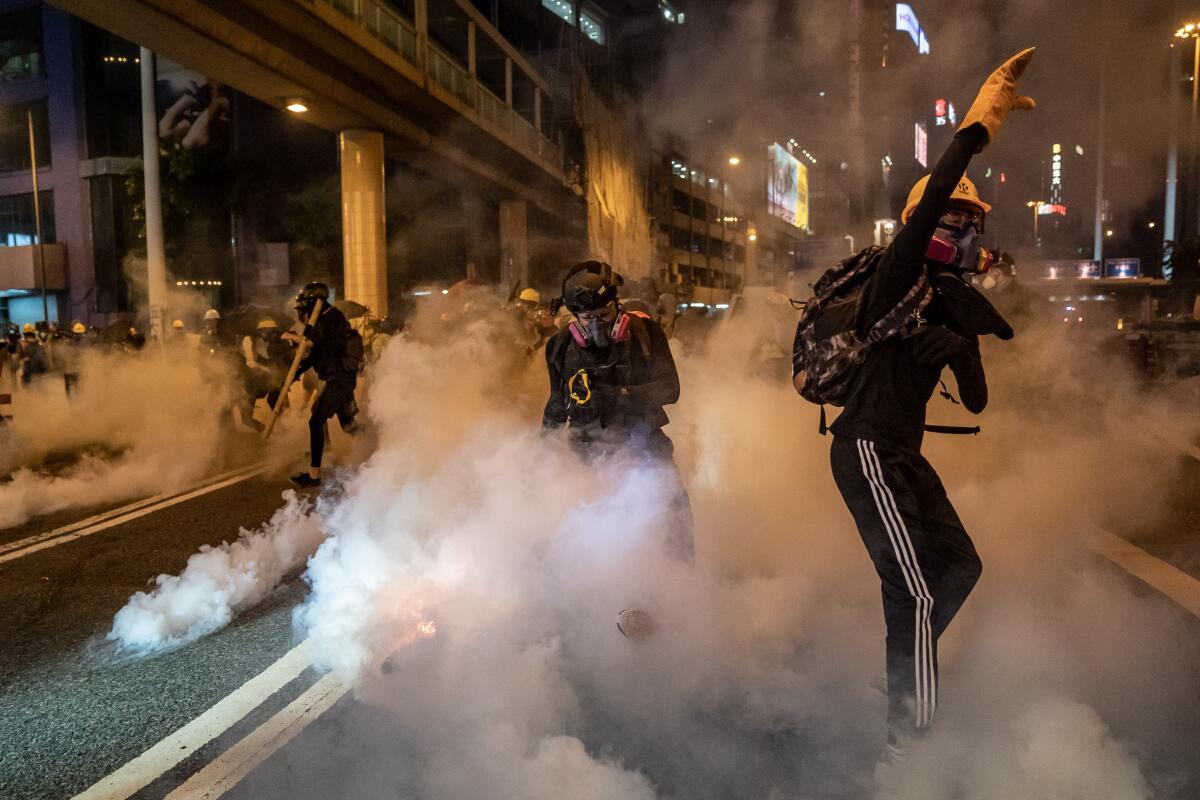 Protesters are enveloped by tear gas Aug. 4 in Hong Kong's Causeway Bay district.