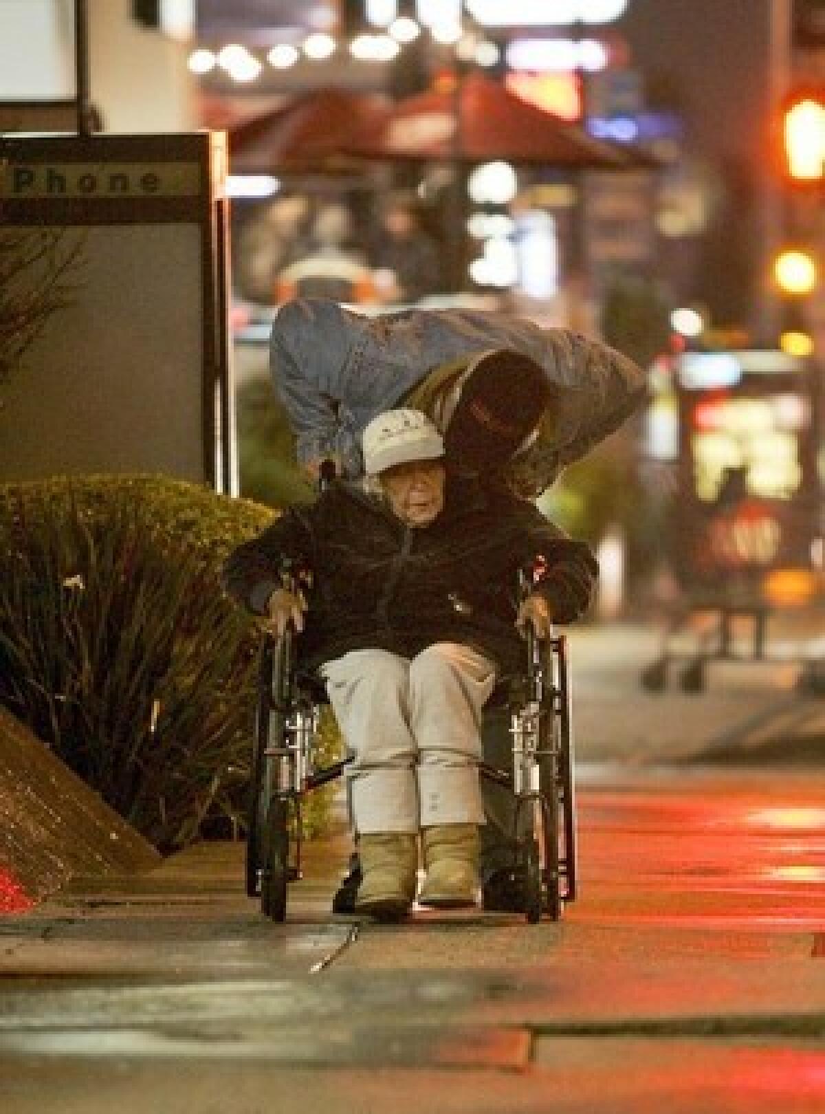 Larry Wilkerson pushes his mother, Bessie Mae Berger, in a wheelchair. They were living in their SUV until October, when a nonprofit stepped in to provide affordable housing.