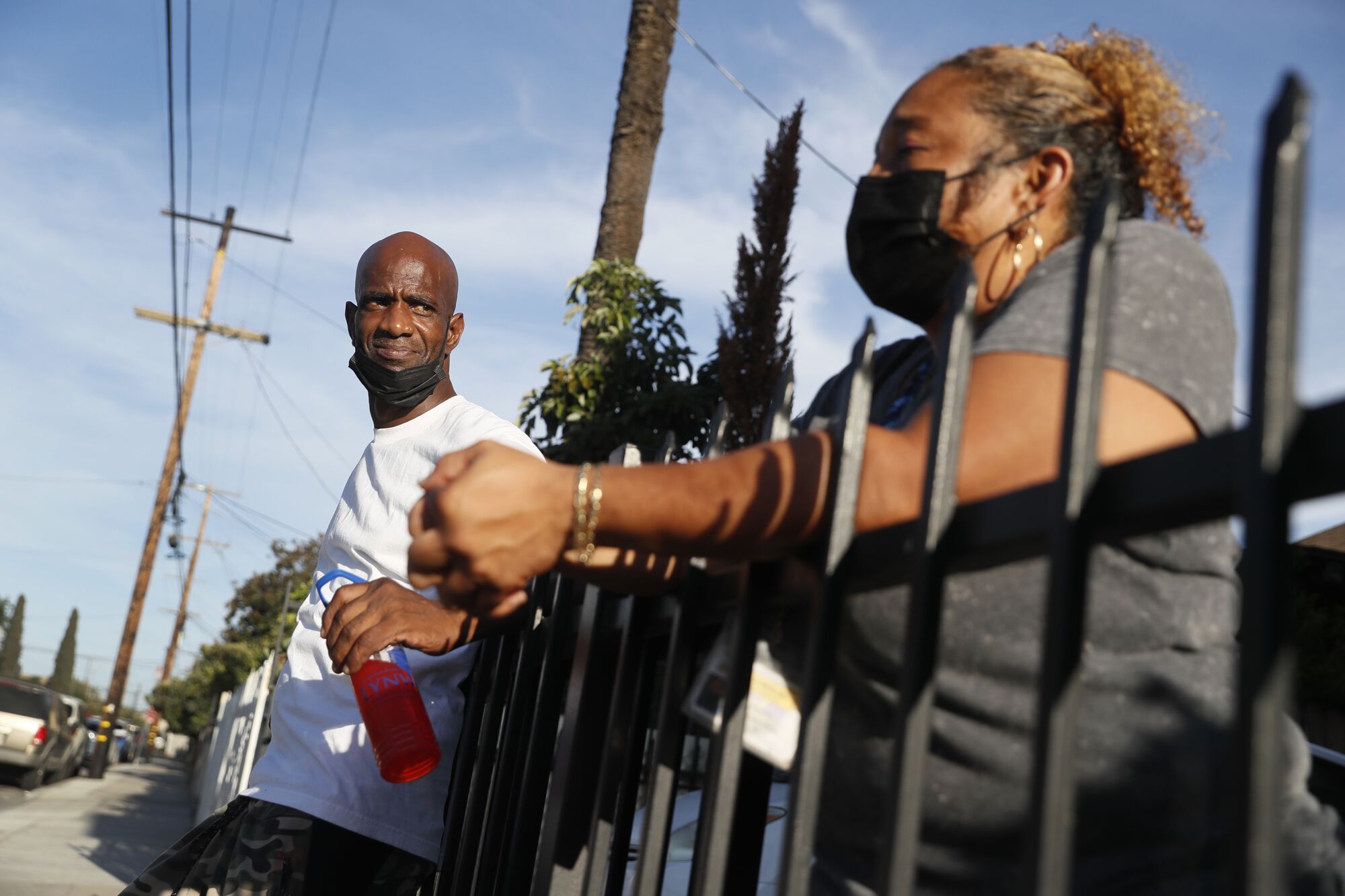 Donald Winston talks with house manager Renee Ohta outside the homeless shelter where he has lived since December.