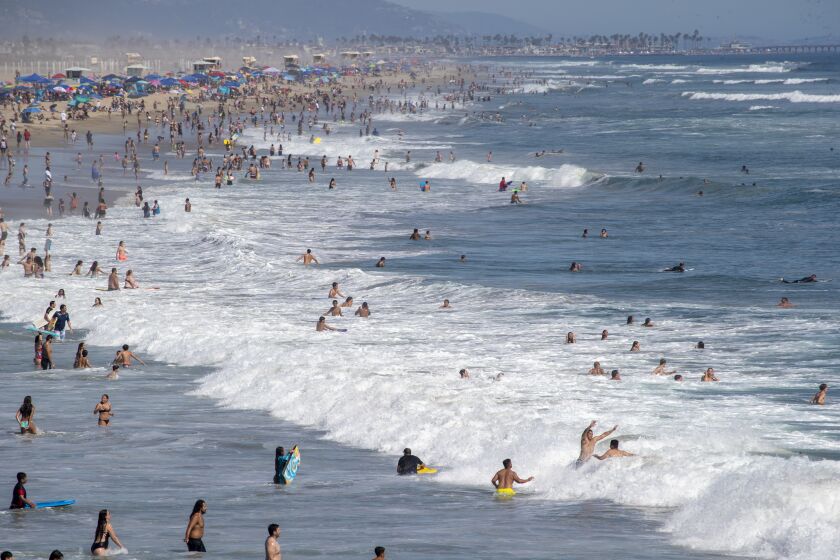 HUNTINGTON BEACH, CA - JUNE 10: Beach goers take to the water to cool off amid high temperatures Wednesday, June 10, 2020 in Huntington Beach, CA. A heat advisory will be in effect today from 11 in the morning until 7 tonight throughout Southern California. (Allen J. Schaben / Los Angeles Times)