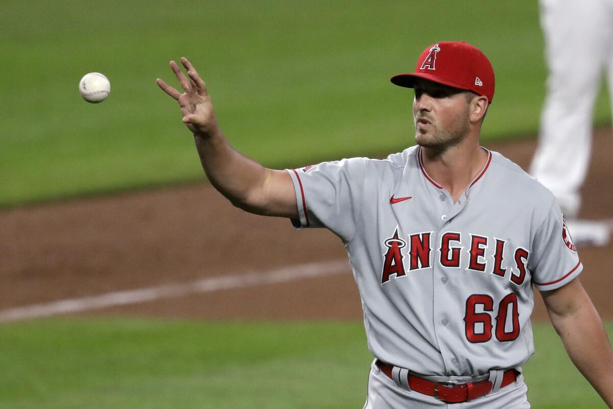 Angels pitcher Mike Mayers reaches for the ball after giving up a run to the Mariners on Aug. 5, 2020, in Seattle.