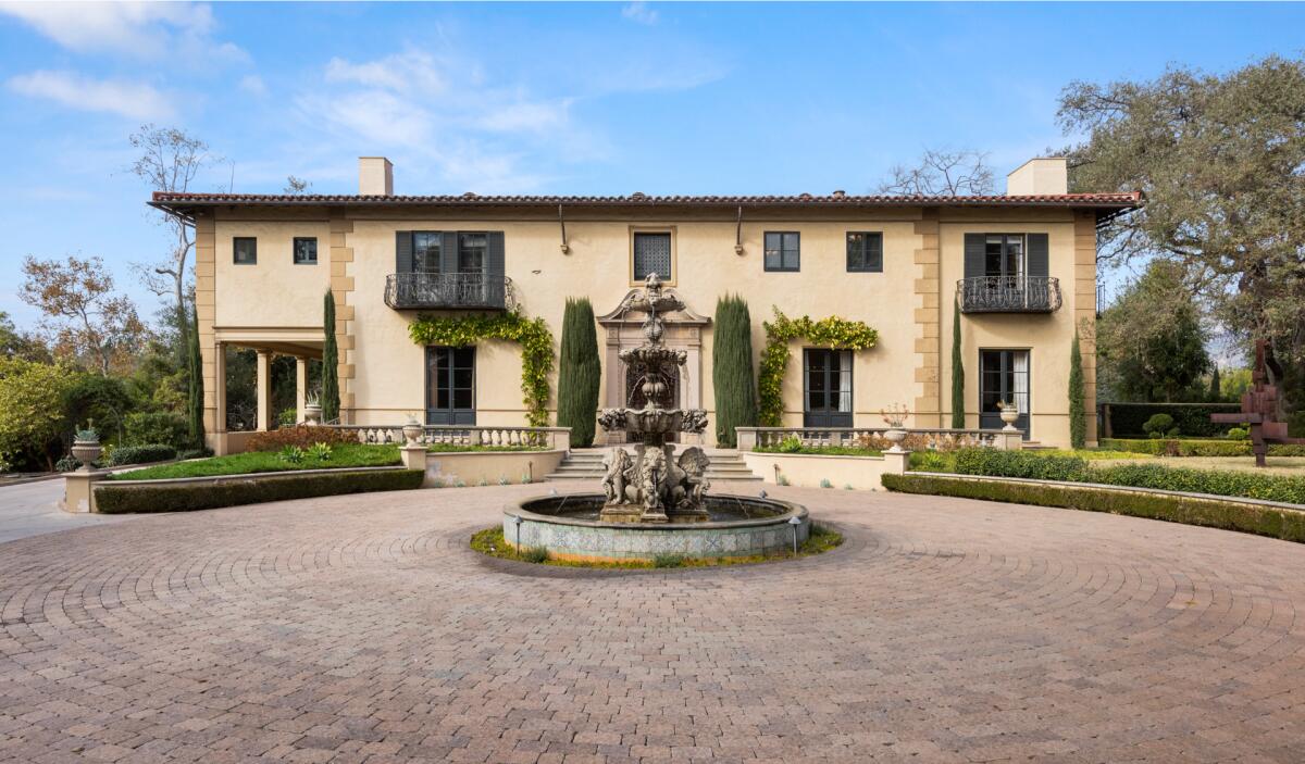 The facade of the home, a fountain and brick motor court.