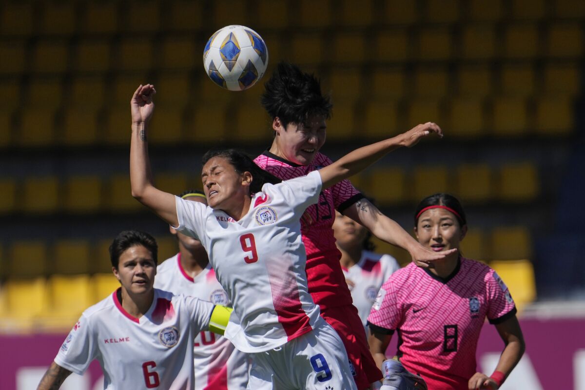 FILE - Philippines' Jessica Miclat, 9, and South Korea's Lee Geum-min jump for the ball during the AFC Women's Asian Cup 2022 match between South Korea and Philippines in Pune, India, Thursday, Feb. 3, 2022. Members of the Philippines’ women football team, which recently made local history by securing their country’s first-ever World Cup spot, have played down social media comments by some fans that most of the players with mixed American ancestry “were not Filipino enough.” (AP Photo/Rajanish Kakade, File)