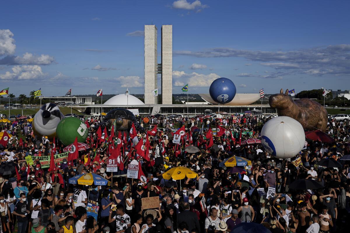 Demonstrators take part in a demonstration by the "Act for the Earth" movement in front of the National Congress in Brasilia, Brazil, Wednesday, March 9, 2022. Hundreds of civil society organizations joined some of Brazil's most famous musicians in an attempt to prevent the passage of the so-called "poison bill" that would loosen restrictions on the use of pesticides, plus demand effective action to contain deforestation in the Amazon and mining on indigenous lands. (AP Photo/Eraldo Peres)
