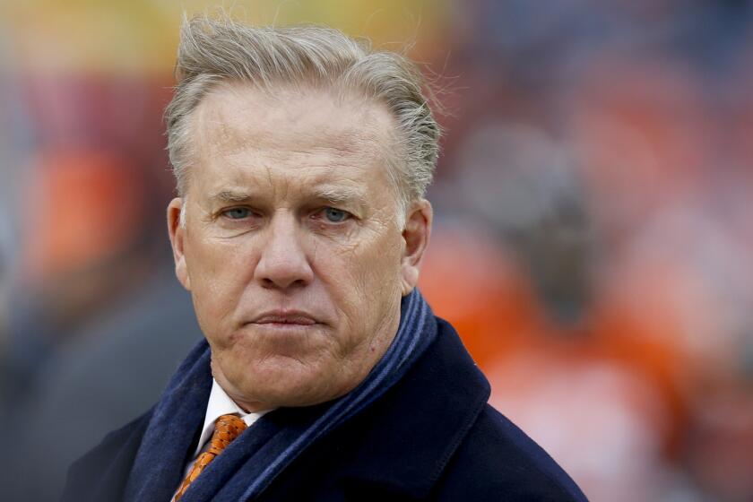 John Elway, Denver Broncos executive vice president and general manager, watches from the sideline during the team's playoff loss to the Indianapolis Colts on Sunday.