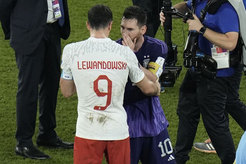 Poland's Robert Lewandowski, left, interacts with Argentina's Lionel Messi at the end of the World Cup group C soccer match between Poland and Argentina at the Stadium 974 in Doha, Qatar, Wednesday, Nov. 30, 2022. (AP Photo/Hassan Ammar)