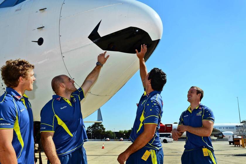 Australian rugby players Michael Hooper, left, Stephen Moore, Dave Dennis and Pat McCabe admire a Qantas jetliner with a mustache painted in its nose to mark Movember, the worldwide fundraiser to help fight prostate cancer.