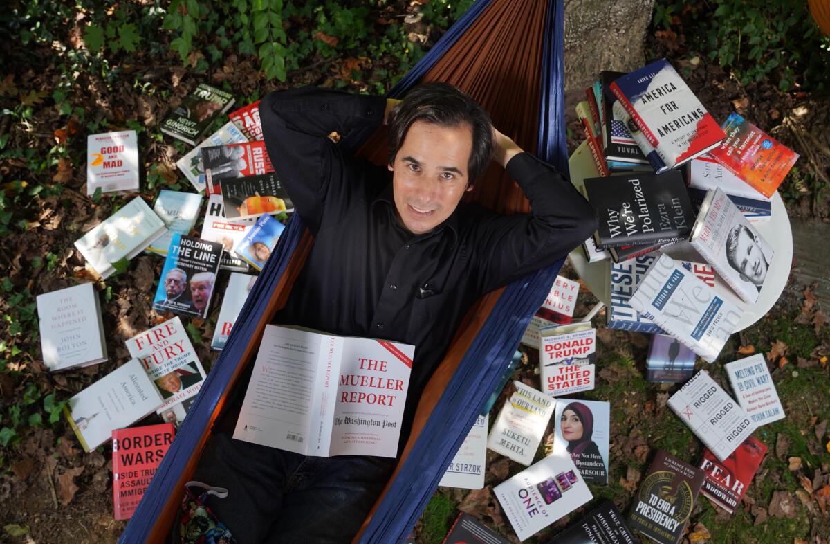 Carlos Lozada with some of the 150 books he read for his metahistory, “What Were We Thinking."