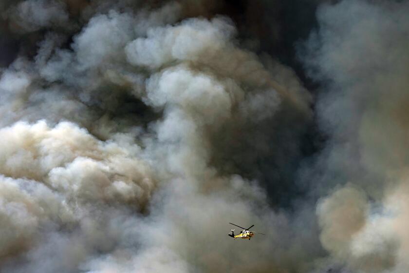 A helicopter flys over the advancing Route Fire over the closed-off interstate 5 Wednesday, Aug. 31, 2022, in Castaic, Calif. (AP Photo/Marcio Jose Sanchez)