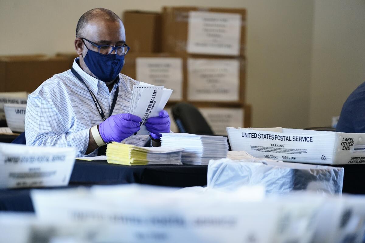 An election inspector looks at an absentee ballot in Atlanta on Wednesday.