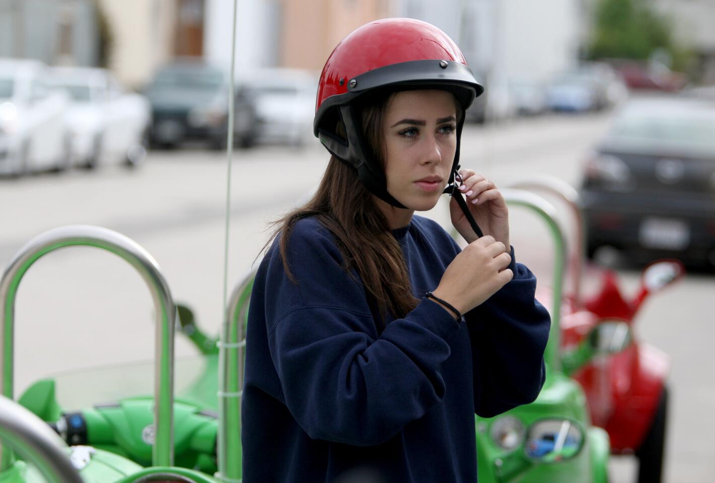 Taylor Kenney, 22 of Los Angeles, puts her helmet on before a three-hour, Red Carpet tour offered by Burbank-based Sunnyday Scoot on Friday, June 5, 2015.