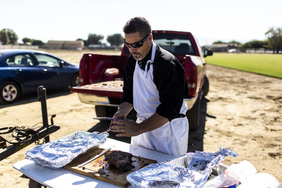 New Jerusalem Supt. David Thoming carves a roast at a fall sports player picnic. Thoming's charter-friendly policy has been lucrative for the school district.