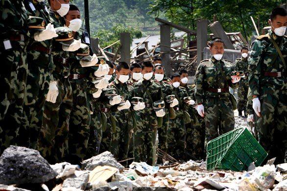 Chinese soldiers observe three minutes of silence Monday in the rubble of a school in earthquake-hit Beichuan County, Sichuan province. From tent cities in Sichuan province to Beijing's Tiananmen Square, sirens wailed and millions of people stood to mourn the tens of thousands who died in last week's earthquake.