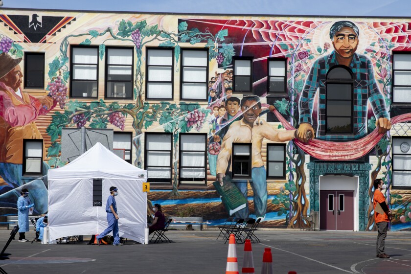  Volunteers and staff with UCSF work to move people through a coronavirus testing site for Mission residents at Cesar Chavez Elementary School in San Francisco.