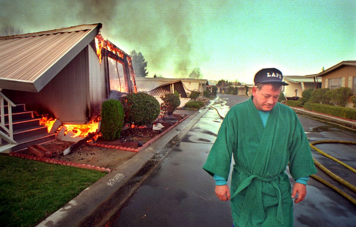 Michael Evans walks through a mobile home park in Santa Clarita. His residence was among those that burned.