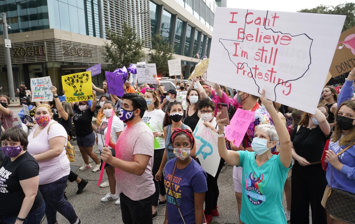 People walk and carry signs at the Houston Women's March.