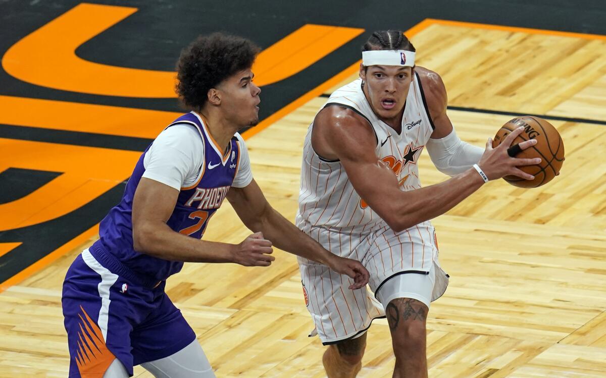 Orlando Magic forward Aaron Gordon, right, looks to pass as he is defended by Phoenix Suns forward Cameron Johnson